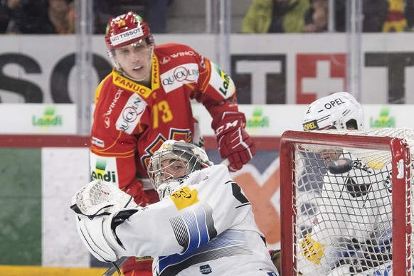 Biels Mike Kuenzle, links, im Duell mit Fribourgs Goalie Reto Berra im Eishockey Meisterschaftsspiel der National League zwischen dem EHC Biel und dem HC Fribourg-Gotteron, am Samstag, 9. Dezember 201 ...