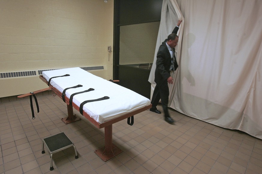 FILE – In this November 2005 file photo, Larry Greene, public information director of the Southern Ohio Correctional Facility, demonstrates how a curtain is pulled between the death chamber and witnes ...