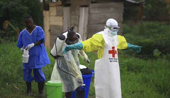 FILE - In this Sunday, Sept 9, 2018 file photo, a health worker sprays disinfectant on his colleague after working at an Ebola treatment centre in Beni, Eastern Congo. Congo&#039;s health ministry say ...