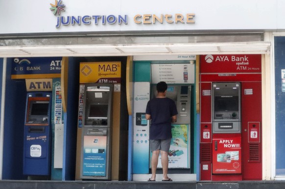 epa08979264 A man withdraws cash from an ATM machine in Yangon, Myanmar, 01 February 2021. The army said that the senior members of the National League for Democracy (NLD), including leader Suu Kyi, a ...