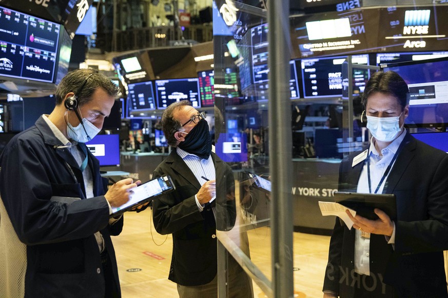 In this photo provided by the New York Stock Exchange, traders work on the floor, Friday, Feb 26, 2021. Stocks wobbled between small gains and losses on Wall Street Friday as rising technology stocks  ...