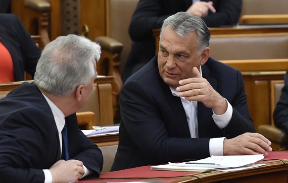 Hungarian Prime Minister Viktor Orban, right, chats with his deputy Zsolt Semjen during a plenary session of the Parliament in Budapest, Hungary, Budapest, Hungary, Monday, March 30, 2020. Hungary&#03 ...