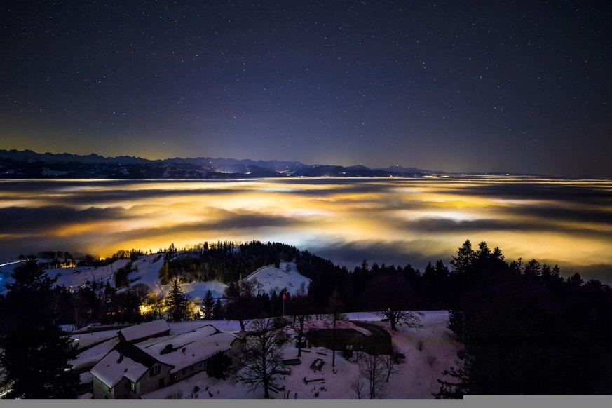Die Sicht vom Bachtelturm in Richtung Zuercher Oberland. Die fleckenartige Beleuchtung entsteht durch die Lichter der Doerfer unter dem Hochnebel am Sonntag, den 24. Dezember 2017 oberhalb von Hinwil. ...