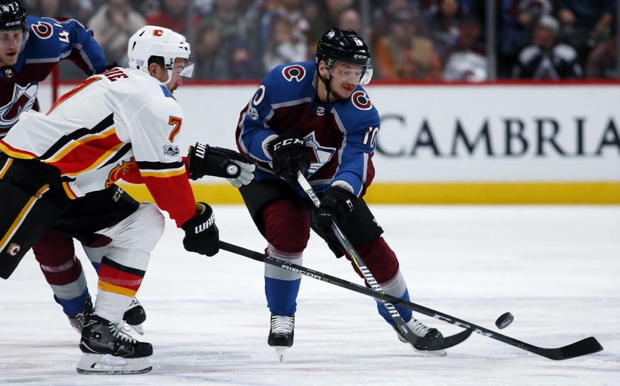 Calgary Flames defenseman TJ Brodie, left, tries to steal the puck from Colorado Avalanche right wing Sven Andrighetto, of Switzerland, as he drives downice in the first period of an NHL hockey game S ...