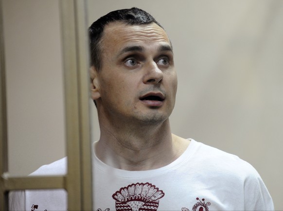FILE - In this Aug. 25, 2015 file photo, Oleg Sentsov stands behind bars as his verdict is read at a court in Rostov-on-Don, Russia. Sentsov, a prominent Ukrainian filmmaker, was convicted of conspiri ...