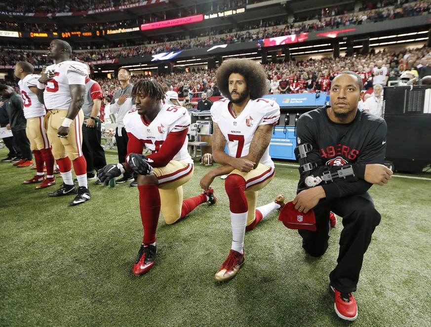 FILE - In this Dec. 18, 2016, file photo, San Francisco 49ers quarterback Colin Kaepernick (7) and outside linebacker Eli Harold (58) kneel during the playing of the national anthem before an NFL foot ...