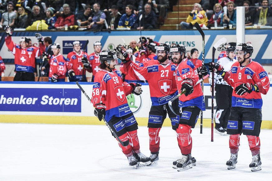 Suisse players Eric Blum, goalgetter Dominik Schlumpf, Denis Hollenstein und Vincent Praplan celebrate after scoring 4:3 during the game between Team Suisse and HC Davos at the 91th Spengler Cup ice h ...