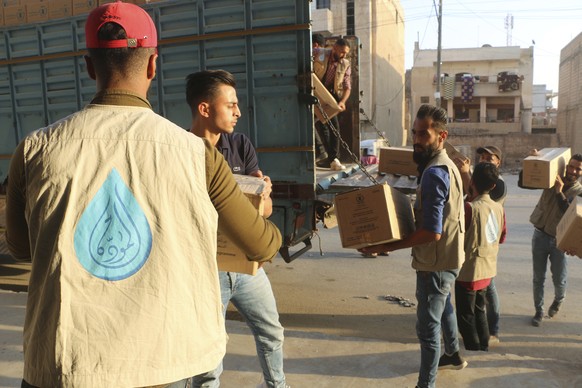 Workers unload boxes of United Nations World Food Programme provisions of fortified date bars enriched with vitamins and minerals from a truck in Hasakeh, some 100km south of the border with Turkey, i ...