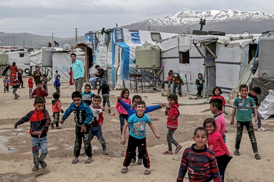 epa08290532 Syrian refugee children poses for the camera in front of makeshift tents at Al Faydah refugee camps, near Zahleh in the Bekaa Valley, Lebanon, 12 March 2020. Syrian refugees are experienci ...