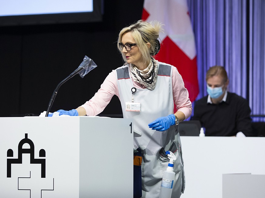 Politik in Pandemiezeiten: Eine Mitarbeiterin des Bundes desinfiziert ein Rednerpult.