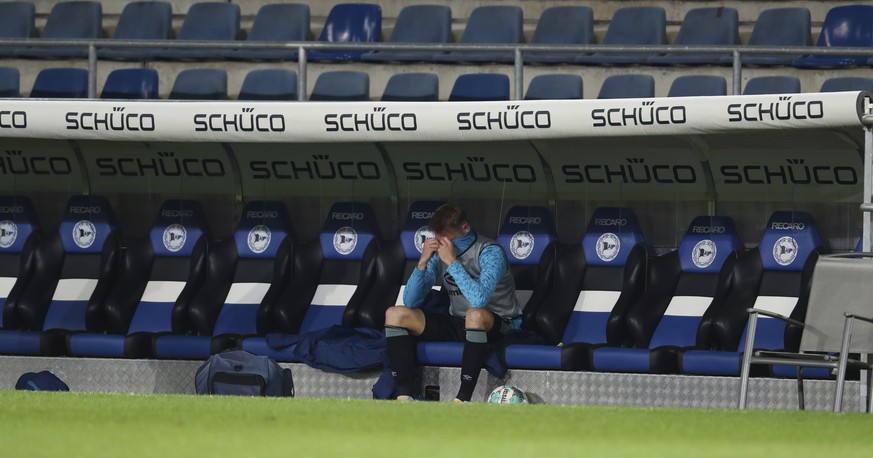 Arena: Schalke defender Timo Becker sits alone on the bench after the German Bundesliga soccer match at Schueco Arena in Bielefeld, Germany, Tuesday April 20, 2021. (Friso Gentsch/pool via AP)