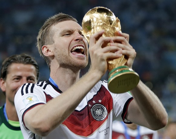 Germany&#039;s Per Mertesacker celebrates with the trophy after the World Cup final soccer match between Germany and Argentina at the Maracana Stadium in Rio de Janeiro, Brazil, Sunday, July 13, 2014. ...