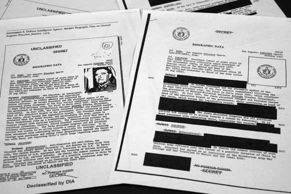 The redacted, right, and the unredacted versions of the biographical intelligence file report on Chilean dictator Augusto Pinochet from 1975 is photographed on April 15, 2019, in Washington. In 2003,  ...