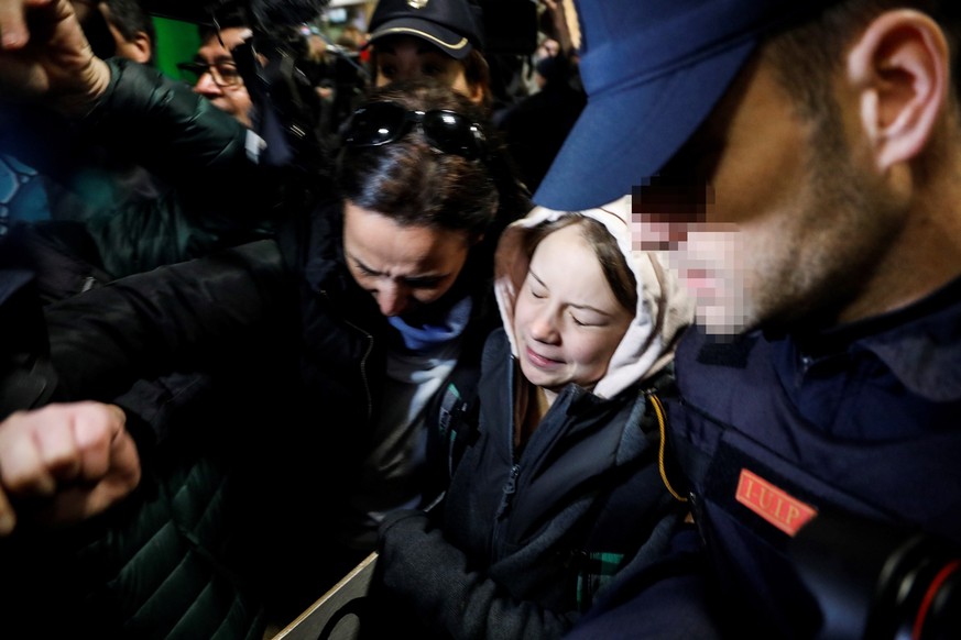 epa08048257 Swedish environmental activist Greta Thunberg (C) is surrounded by journalists upon her arrival at Chamartin Railway Station, in Madrid, Spain, early 06 December 2019. Greta arrived in Mad ...