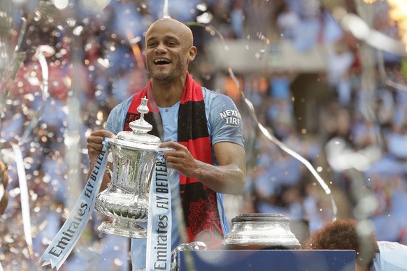 Manchester City&#039;s team captain Vincent Kompany lifts the trophy after winning the English FA Cup Final soccer match between Manchester City and Watford at Wembley stadium in London, Saturday, May ...