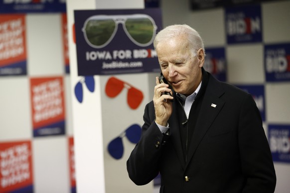 Democratic presidential candidate former Vice President Joe Biden speaks with a potential caucus-goer during a stop at a campaign field office, Monday, Jan. 13, 2020, in Des Moines, Iowa. (AP Photo/Pa ...