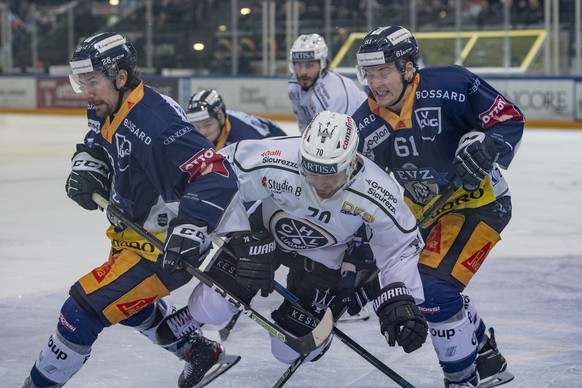 Matteo Romanenghi, mitte, von Lugano im Spiel gegen Yannick-Lennard Albrechts, links, und Sven Leuenberger, rechts, von Zug beim Eishockey Meisterschaftsspiel in der Qualifikation der National League  ...