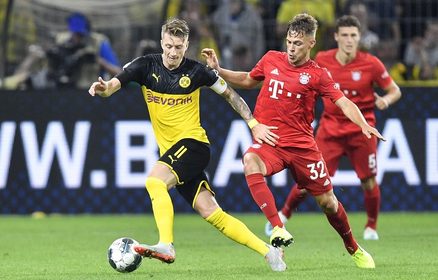 Dortmund&#039;s Marco Reus, left, and Bayern&#039;s Joshua Kimmich challenge for the ball during the German Super Cup soccer match between Borussia Dortmund and Bayern Munich in Dortmund, Germany, Sat ...