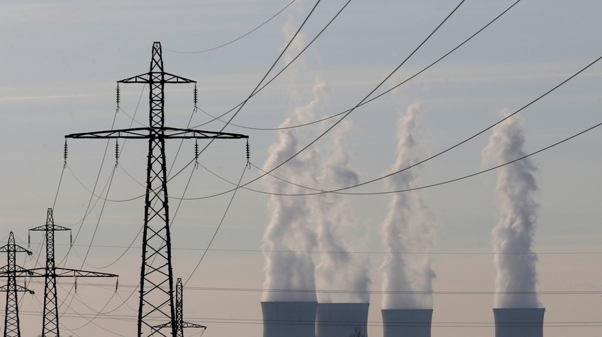 Electrical power pylons of high-tension electricity power lines are seen near the cooling towers of the Electricite de France (EDF) nuclear power station in Dampierre-en-Burly, in this March 8, 2015 f ...