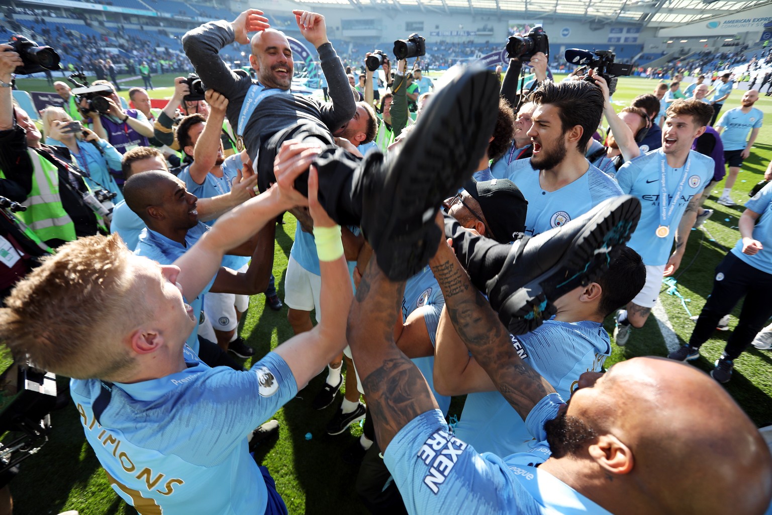 epa07565191 Manchester City manager Pep Guardiola is lifted by his players after the English Premier League match between Brighton and Hove Albion and Manchester City, Brighton, Britain, 12 May 2019.  ...