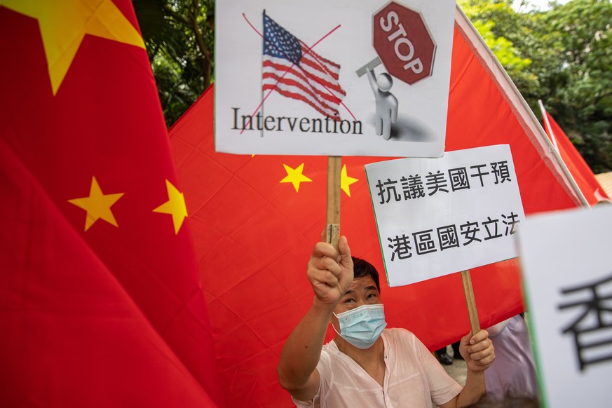 epa08509938 A group of pro-China activists hold banners and Chinese national flags during a march to the US Consulate General in Hong Kong, China, 26 June 2020. Demonstrators were protesting against t ...