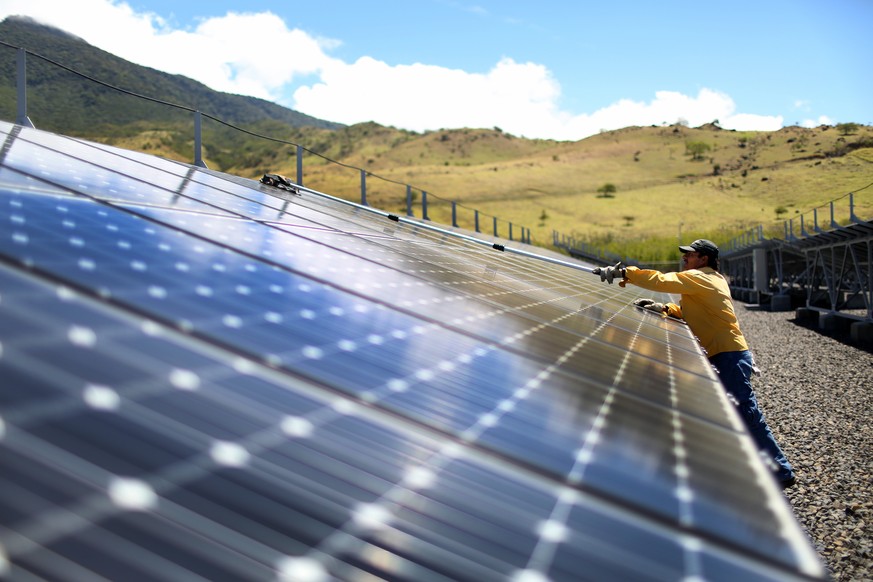GUANACASTE, COSTA RICA - MARCH 26: A worker cleans the panels in a solar power park run by the Costa Rican Electricity Institute (ICE) as the power company has managed to produce all of the electricit ...