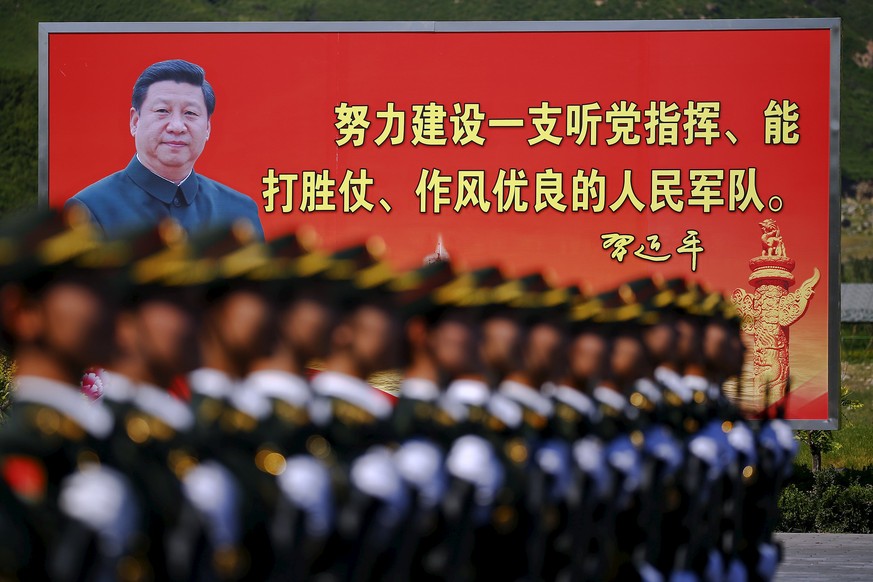 Soldaten vor einem riesigen Plakat mit Chinas Präsidenten Xi Jinping.