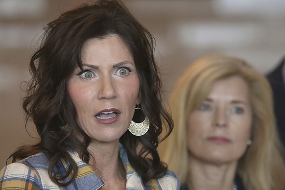 FILE - In this March 18, 2020, file photo, South Dakota Gov. Kristi Noem, left, updates media on the COVID-19 pandemic during a press conference at Monument Health in Rapid City, S.D. The number of pe ...