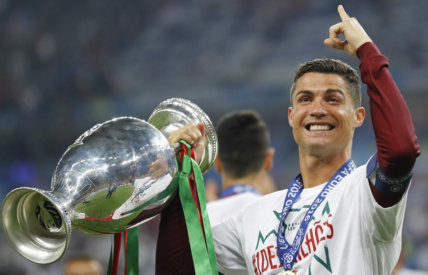 FILE - In this Sunday, July 10, 2016 file photo, Portugal&#039;s Cristiano Ronaldo celebrates with the trophy at the end of the Euro 2016 final soccer match between Portugal and France at the Stade de ...