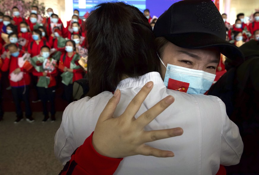 A medical worker from China&#039;s Jilin Province reacts as she prepares to return home at Wuhan Tianhe International Airport in Wuhan in central China&#039;s Hubei Province, Wednesday, April 8, 2020. ...