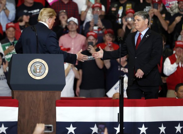 President Donald Trump shakes hands with Fox News Channel&#039;s Sean Hannity, right, during a campaign rally Monday, Nov. 5, 2018, in Cape Girardeau, Mo. (AP Photo/Jeff Roberson)