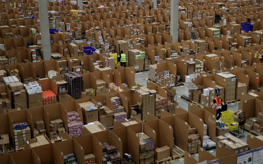 epa06355787 Workers at the Amazon logistics and distribution center in Rheinberg, Germany, 28 November 2017. The Amazon logistics center is directly connected to a &#039;Deutsche Post&#039; DHL shippi ...