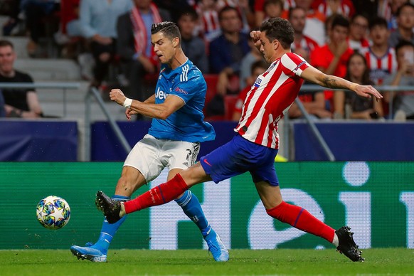 epa07852150 Juventus&#039; forward Cristiano Ronaldo (L) in action against Jose Gimenez (R) of Atletico Madrid during the UEFA Champions League group D soccer match between Atletico Madrid and Juventu ...