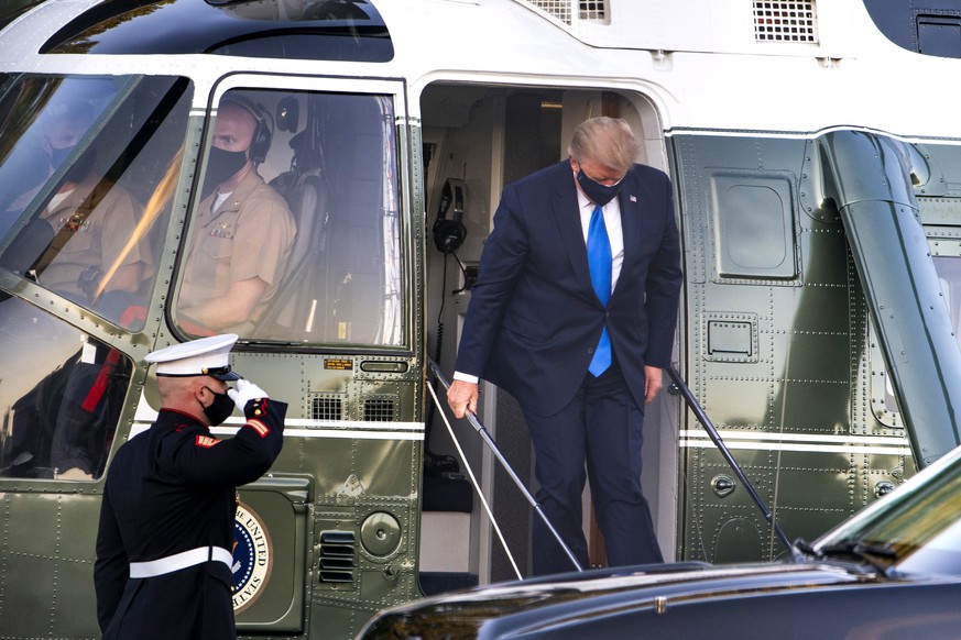 epa08716529 US President Donald J. Trump walks off Marine One after landing at Walter Reed National Military Medical Center following his announcement that he and First Lady Melania tested positive fo ...