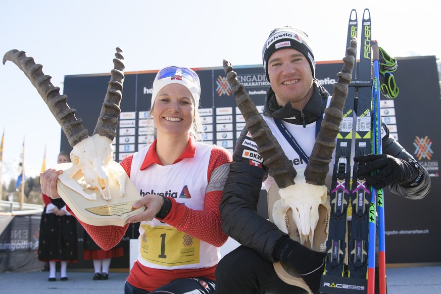 Winners Dario Cologna, right, of Switzerland and Mari Eide of Norway pose during the winner ceremony at the annual Engadin skiing marathon in S-Chanf, Switzerland on Sunday, March 12, 2017. (Gian Ehre ...