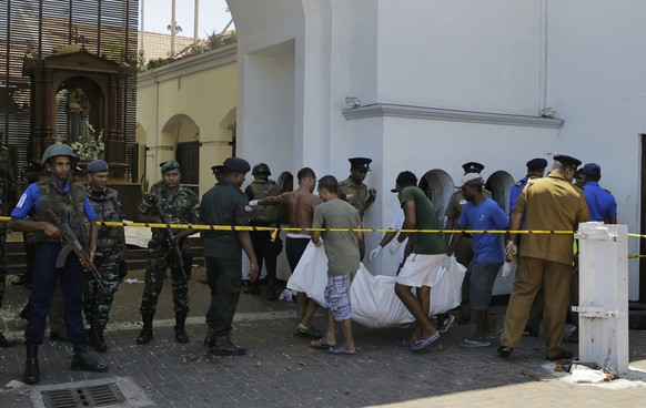 Sri Lankans carry a dead body following a blast at the St. Anthony&#039;s Church in Colombo, Sri Lanka, Sunday, April 21, 2019. More than hundred people were killed and hundreds more hospitalized from ...