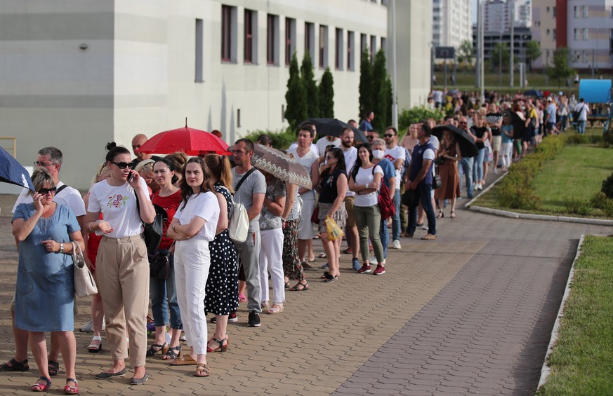 epa08593805 Belarusian people queue outside a polling station to cast their votes during the presidential elections in Minsk, Belarus, 09 August 2020. Five candidates are contesting for the presidenti ...