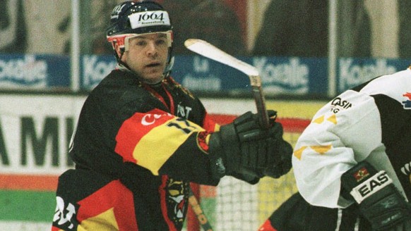 Der Berner Gates Orlando (links) kontrolliert in der NLA-Eishockey-Partie Lugano-Bern am Samstag, 29. November 1997, in Lugano den Lugano-Stuermer Todd Elik (rechts) vor dem Berner Tor mit Hueter Rena ...