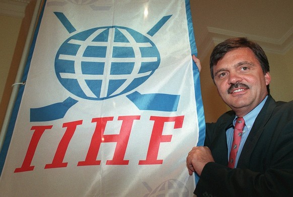 International ice hockey Federation out-going president, Rene Fasel of Switzerland, poses with the new flag of the Federation at the opening day of the IIHF congress in Lausanne, Switzerland, May 31,  ...
