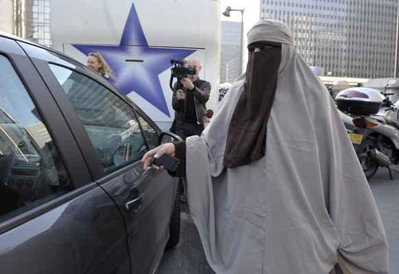 epa02681777 Kenza Drider wearing niqab leaves Gare de Lyon train station in Paris, France by car on 11 April 2011 after arriving from Avignon for a protest. France officially banned women from wearing ...