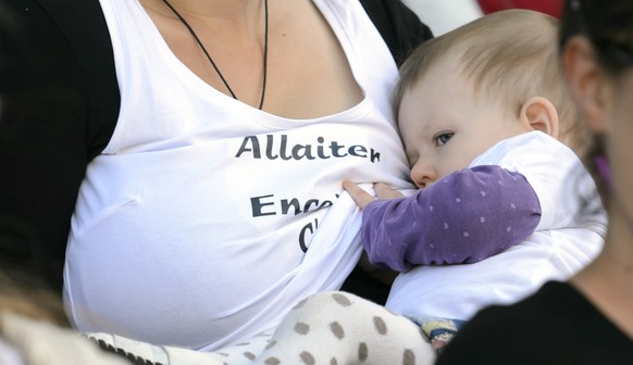 A mom nurses a baby during a flash mob protest to promote breastfeeding during the at the Place de la Riponne, in Lausanne, Saturday, September 13, 2014. 50 women gathered together and feed their baby ...