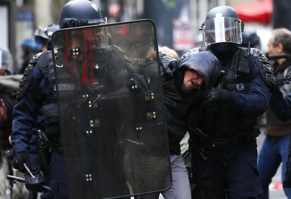 FILE - In this Oct. 10, 2017 file photo, riot police officers detain a demonstrator during a protest in Paris. As videos helped reveal many cases of police brutality, French civil rights activists voi ...