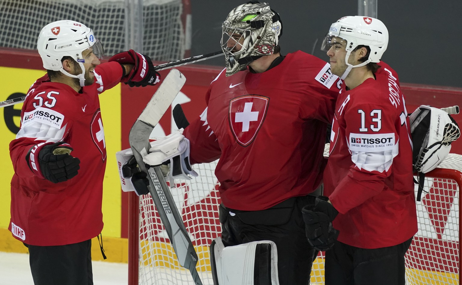 From left, Romain Loeffel, Reto Berra and Nico Hischier of Switzerland celebrates after the Ice Hockey World Championship group A match between Switzerland and Slovakia at the Olympic Sports Center in ...