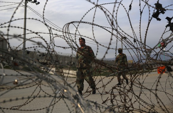 Afghan National Army soldiers stand guard at a checkpoint near the Bagram base in northern Kabul, Afghanistan, Wednesday, April 8, 2020. An Afghan official said Wednesday that the country has released ...