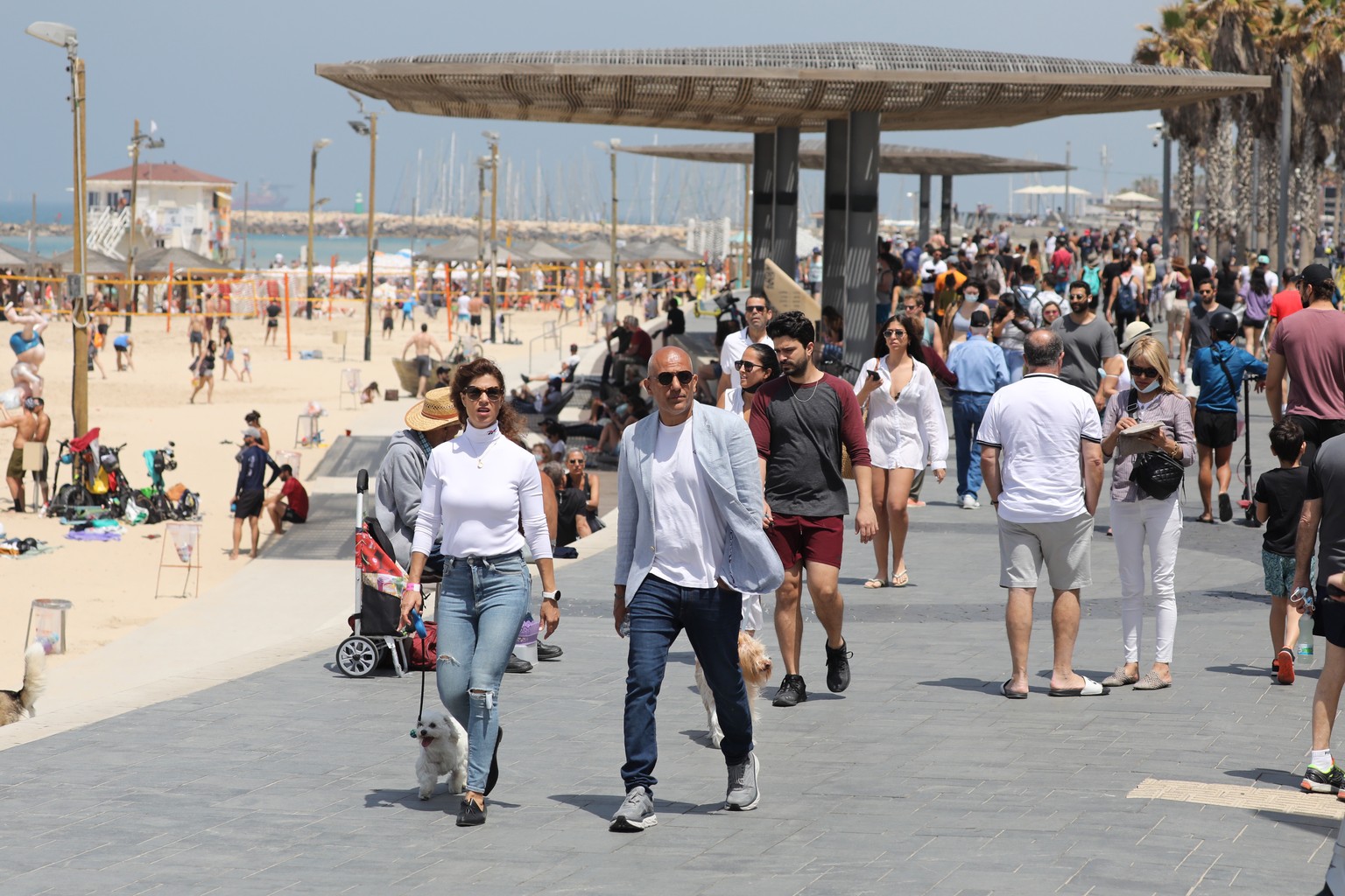 epa09140970 People without face masks enjoy the weather on the beach of Tel Aviv, 17 April 2021. Israel ends obligatory use of face masks outdoors starting from 18 April following a successful vaccina ...