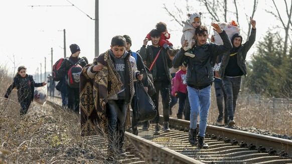 Migrants walk on the railway tracks heading for Greece near the Pazarakule border crossing in Edirne, Turkey, Sunday, March. 1, 2020. The United Nations migration organization said Sunday that at leas ...