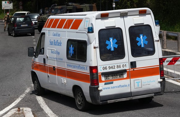 An ambulance of the San Raffaele health care and hospice structure drives past a road block on its way to the San Raffaele hospice after, according to reports, over 70 people inside tested positive to ...