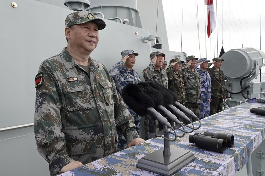 In this April 12, 2018 photo released by Xinhua News Agency, Chinese President Xi Jinping, left, speaks after he reviewed the Chinese People&#039;s Liberation Army (PLA) Navy fleet in the South China  ...