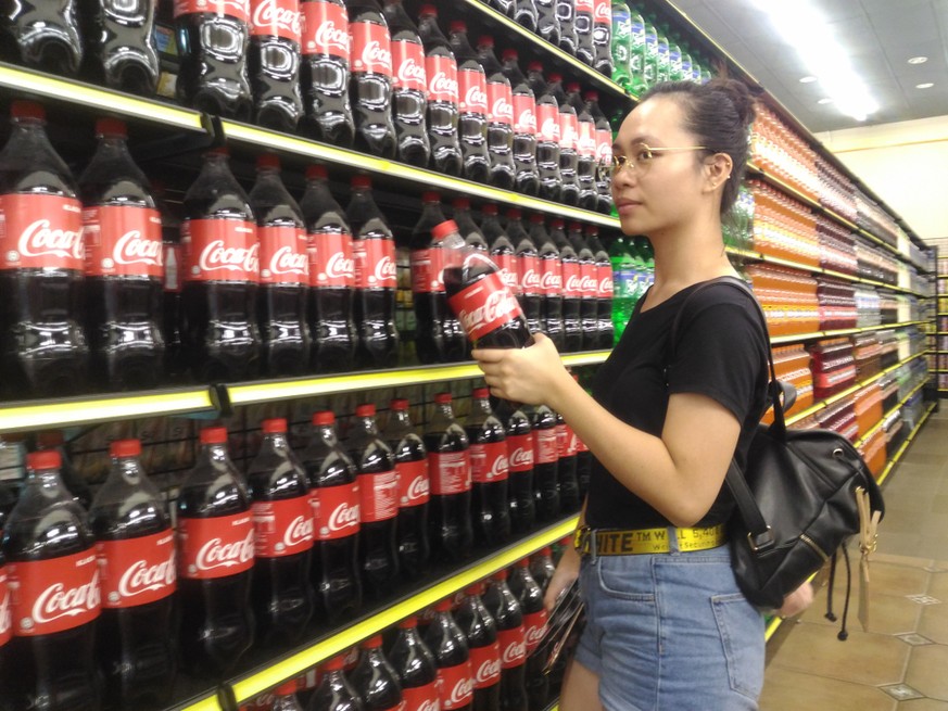 Eine Frau gönnt sich in Malaysia eine Cola.