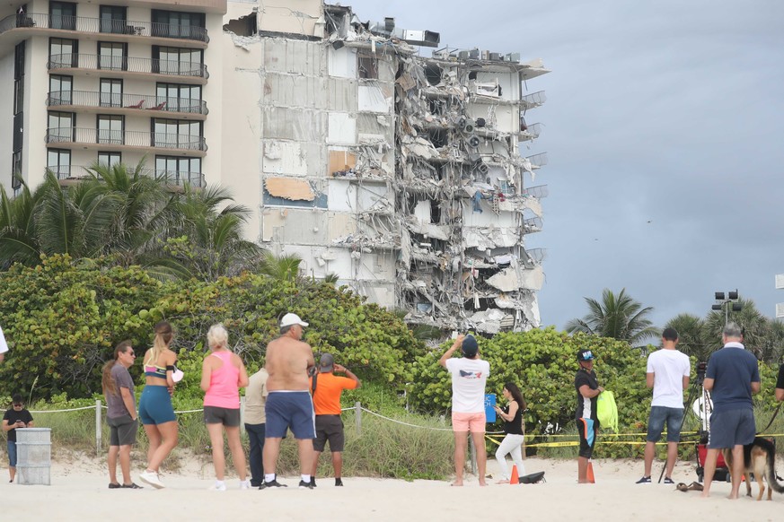 People look at the damage at the 12-story oceanfront Champlain Towers South Condo that collapsed early Thursday, June 24, 2021 in Surfside, Fla.